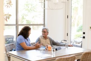Nurse and older adult male discussion medications
