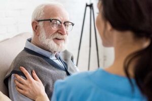 patient with glasses talks with nurse about at home hospice care