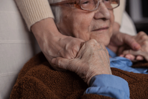 patient holds hands of loved one as they discuss common end of life signs