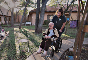 man assists woman in wheelchair with hospice donations