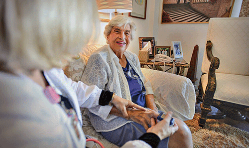 woman on couch receiving home infusion therapy