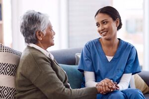 patient and nurse clasp hands and discuss hospice care for advanced pulmonary fibrosis