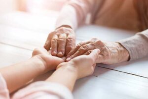 shot of people holding hands while discussing hospice for end stage heart failure