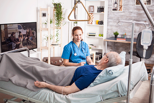nurse assists man in hospice care