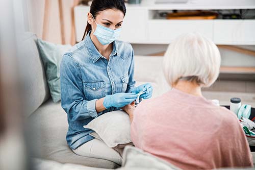 patient and nurse with face mask discuss hospice safety during the covid 19 crisis