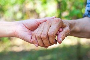 shot of clasped hands as doctor explains choosing his own path to hospice care