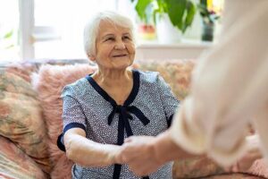 patient holds hands of hospice care worker while discussing how to change hospice care providers