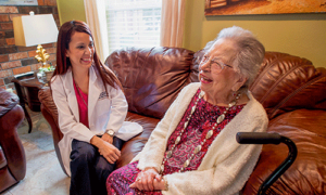 woman receiving care services laughs with doctor
