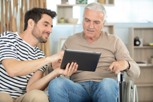 man shows loved one how paying for palliative care works on a tablet