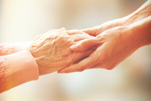 shot of hands reaching out while discussing paying for hospice care