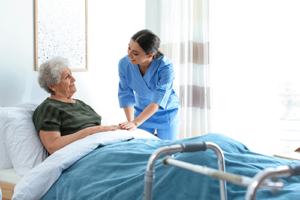 patient in bed talks with nurse about preparing for at home hospice care