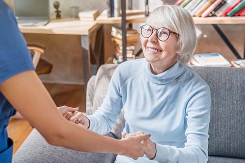 woman in turtleneck smiles while discussing what hospice routine wound care is