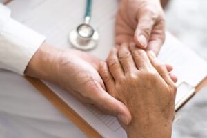 shot of doctor holding patient hand as they discuss what a post form is and why someone might need one