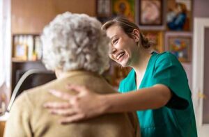 nurse places hand on woman's back while discussing what hospice respite care is