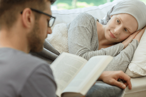 a man reads to a woman who lays in bed and struggling with an illness while wondering who needs palliative care