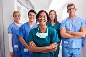 nurses in group smile while discussing who the members of a hospice care team are