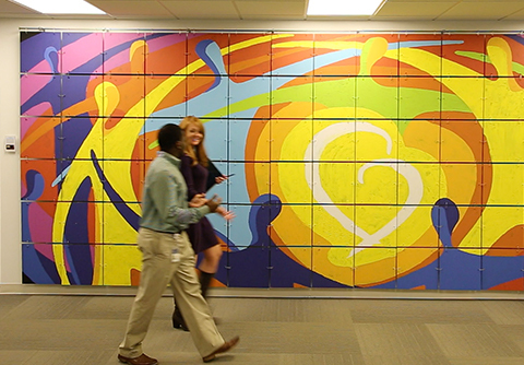 employees walk through hall while discussing compassus company culture