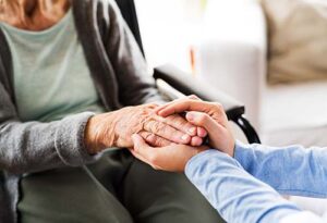patient holding hands with loved one while discussing hospice criteria for renal disease