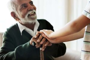 man holding the hand of nurse discusses hospice criteria for cancer