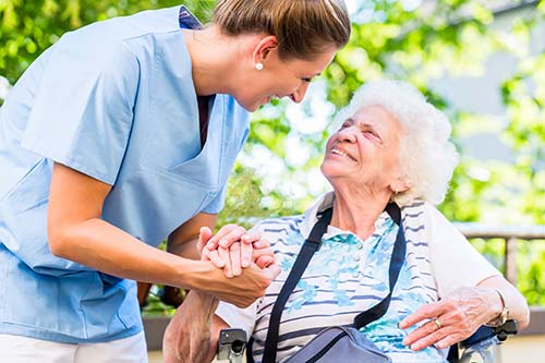 nurse holds hand of patient while discussing hospice and medicare advantage plans