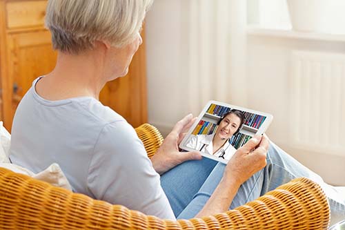 woman talks with healthcare provider through telehealth palliative care