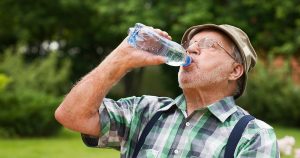 Older male drinking bottle of water
