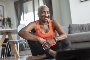 Older adult woman sitting & smiling during exercise.