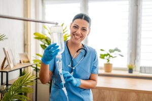 Home Care Nurse Preparing An IV Drip Indoors